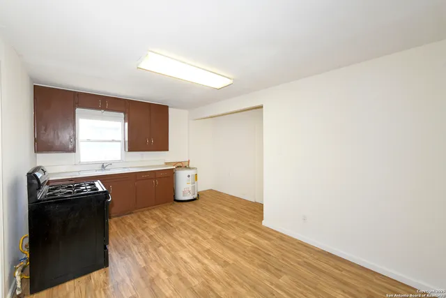 a kitchen with granite countertop a stove a sink and a refrigerator