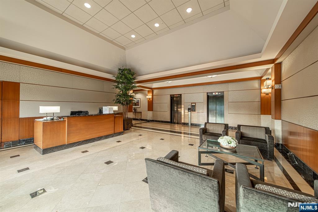 6 Horizon Road, Unit 906 Fort Lee, NJ 07024 - Photo 7 of 12 a lobby with furniture and flat screen tv