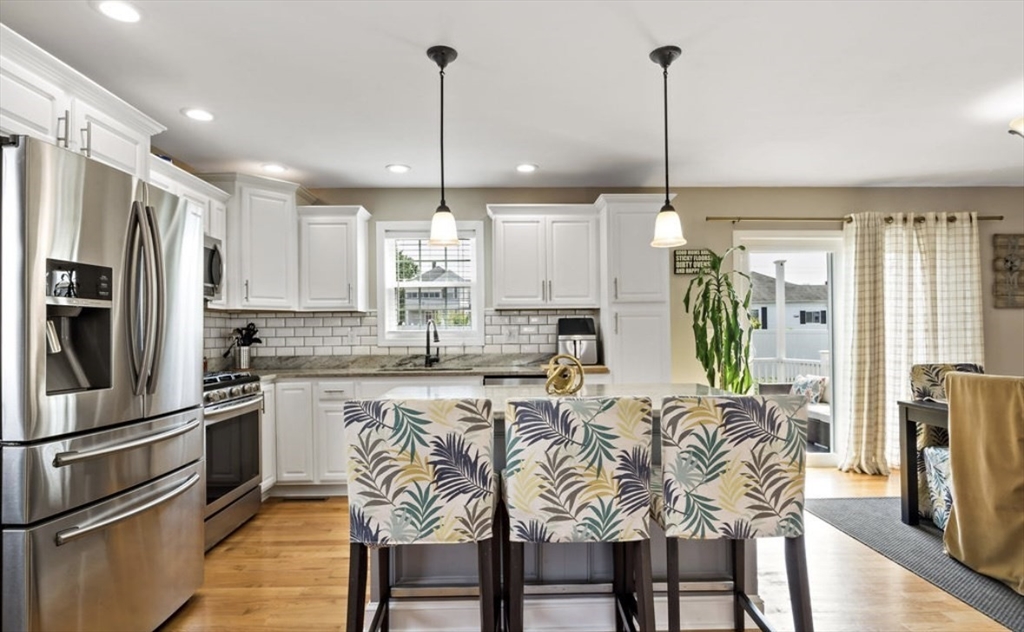 357 Ludlow Street Fall River, MA 02721 - Photo 5 of 19 a kitchen with stainless steel appliances granite countertop a refrigerator a stove a sink dishwasher a dining table and chairs with wooden floor