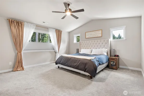 a spacious bedroom with a bed and a chandelier