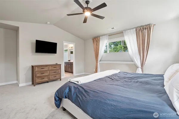 a bed room with furniture a flat screen tv and a fireplace