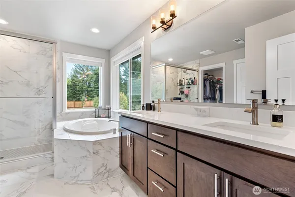 a bathroom with a double vanity sink large mirror and bathtub