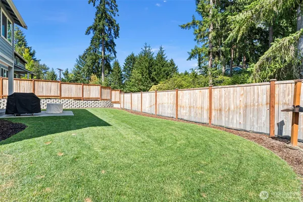a view of a backyard with a garden and wooden fence
