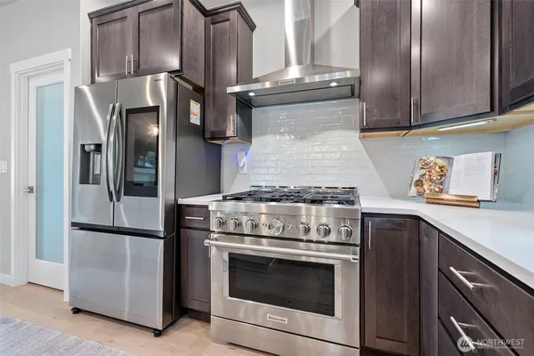 a kitchen with stainless steel appliances granite countertop a stove and a refrigerator with cabinets
