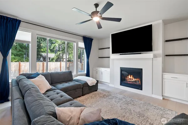 a living room with furniture a flat screen tv and a fireplace
