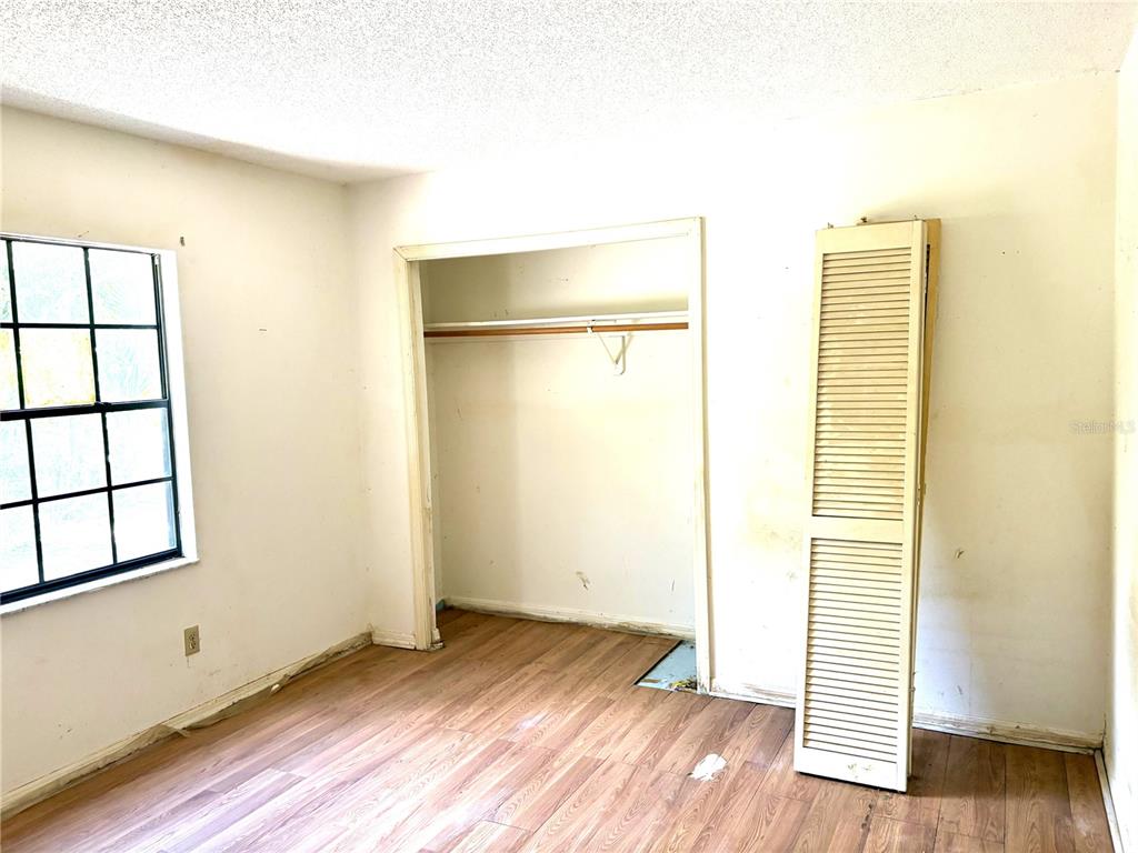 795 Scooter Point Geneva, FL 32732 - Photo 11 of 12 an empty room with wooden floor and windows