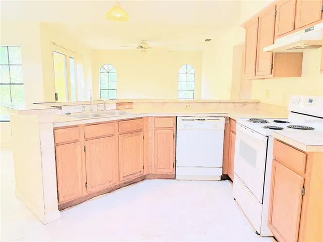 a kitchen with granite countertop a sink and white cabinets