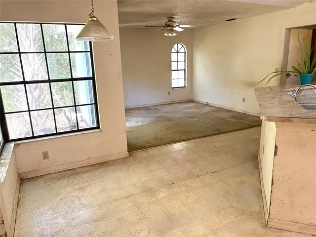 an empty room with windows and fan