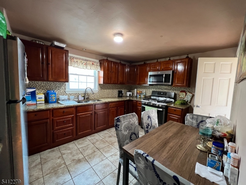 220 Terrill Road Plainfield, NJ 07062 - Photo 4 of 15 a kitchen with granite countertop wooden cabinets a stove top oven a granite counter space and a window
