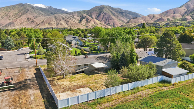 810 East Maple Street Mapleton, UT 84664 - Photo 49 of 49 Expansive parcel featuring a white privacy fence, mature trees, and a mountain backdrop
