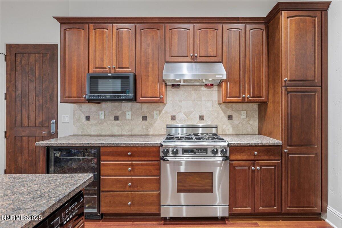6355 Wetzel Court Reno, NV 89511 - Photo 11 of 38 a kitchen with granite countertop wooden cabinets and a stove top oven