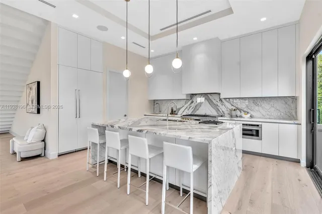 a kitchen with kitchen island a large window in it