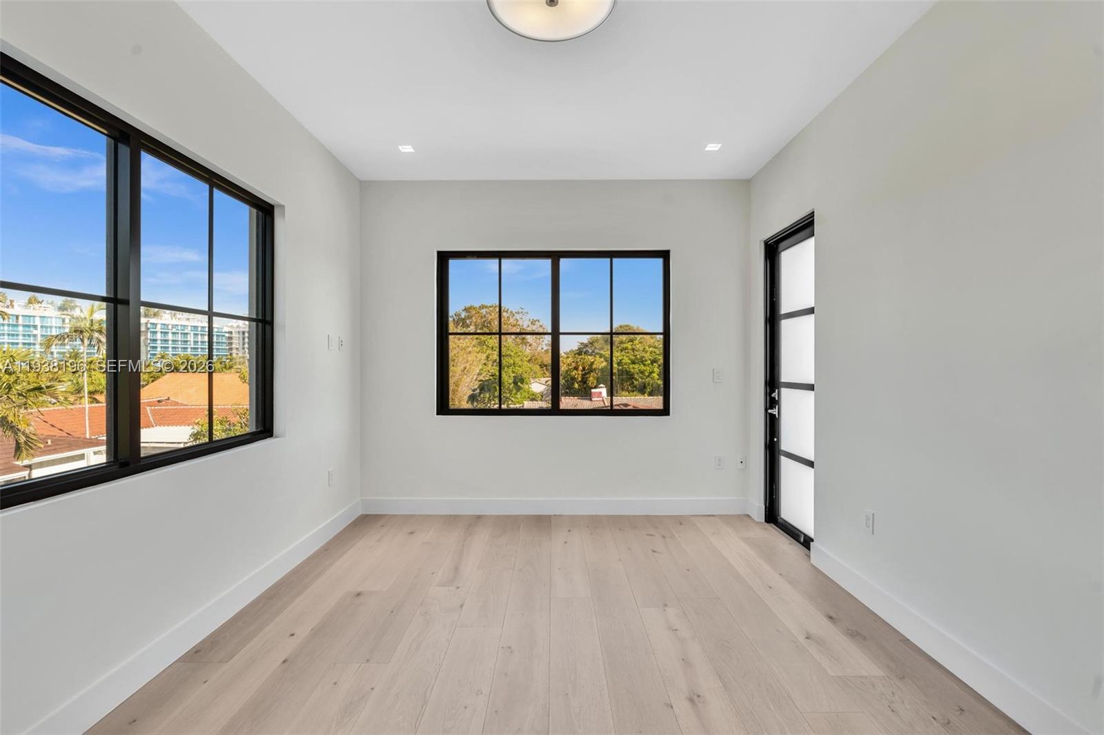 9264 Dickens Avenue Surfside, FL 33154 - Photo 21 of 46 wooden floor in an empty room with a window