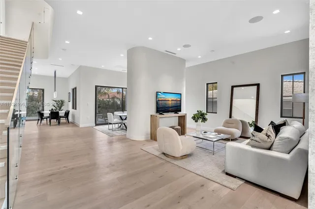 a dining room with wooden floor and large windows