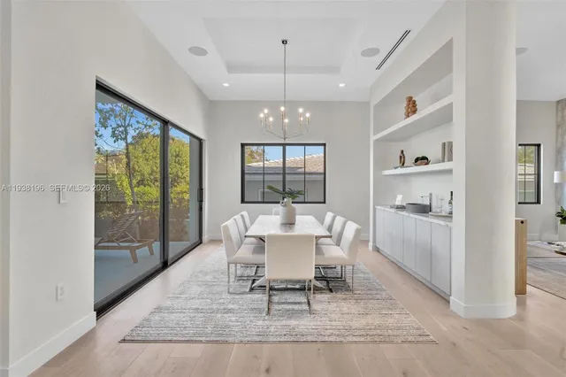 a view of a dining room with furniture a chandelier and wooden floor