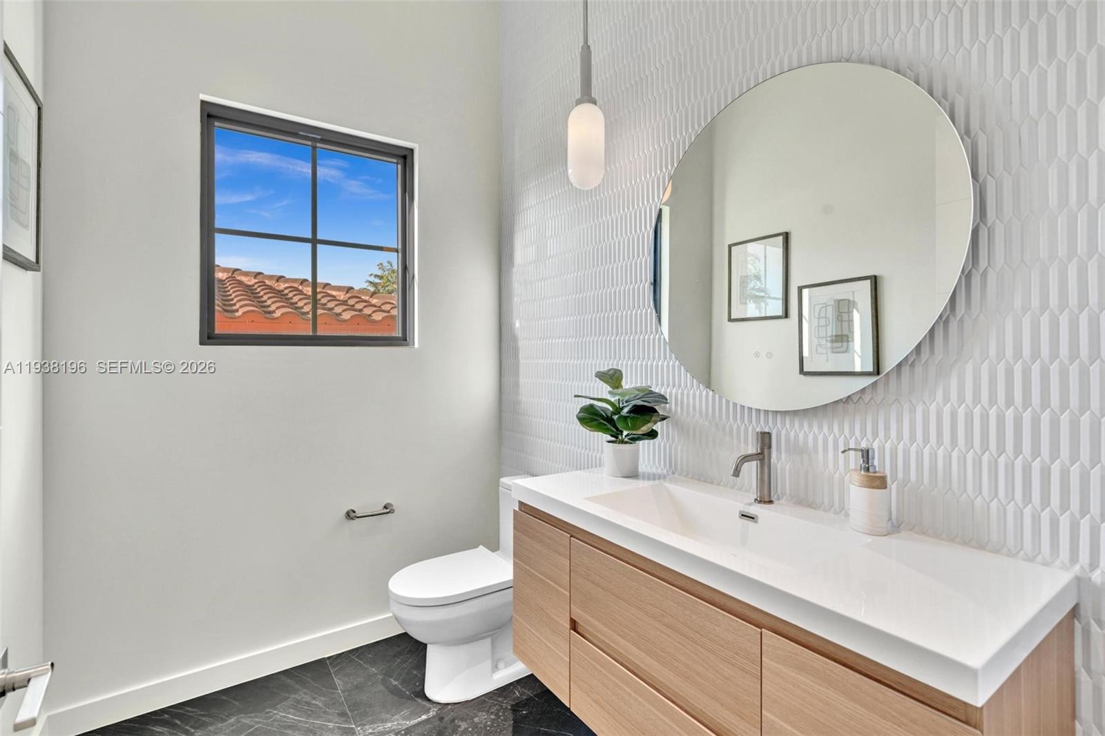 9264 Dickens Avenue Surfside, FL 33154 - Photo 10 of 46 a bathroom with a toilet sink and mirror