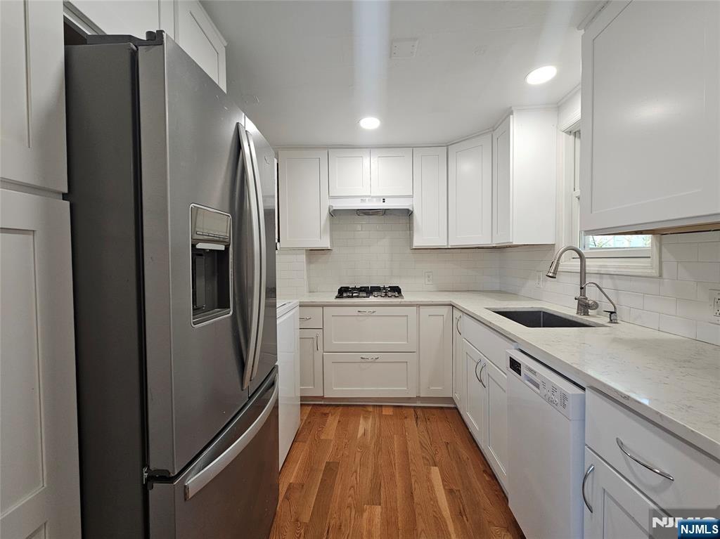 a kitchen with stainless steel appliances a refrigerator sink and cabinets