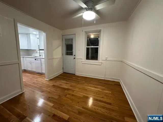 a view of empty room with wooden floor and window