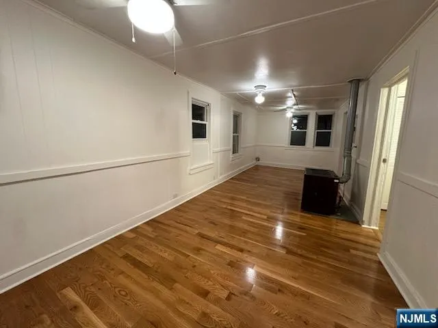 a view of empty room with wooden floor