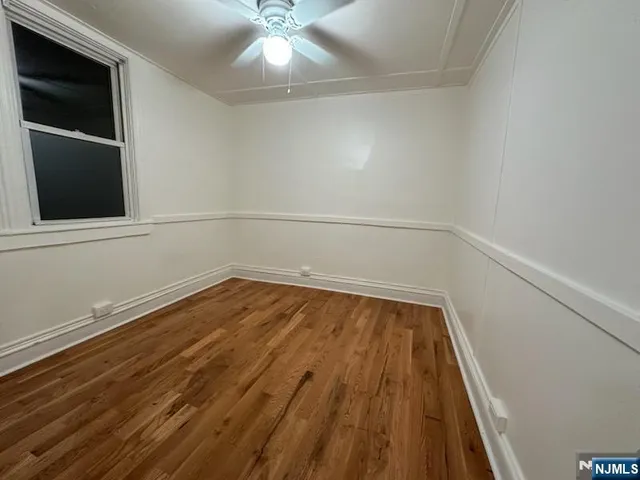 a view of a room with wooden floor and fan