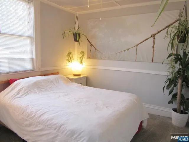 a bedroom with a bed and a potted plant