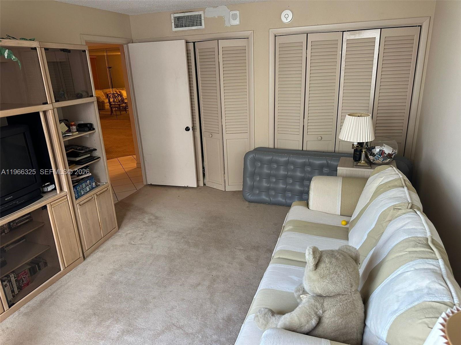 6039 Collins Avenue, Unit 1517 Miami Beach, FL 33140 - Photo 17 of 54 a living room with furniture and a flat screen tv