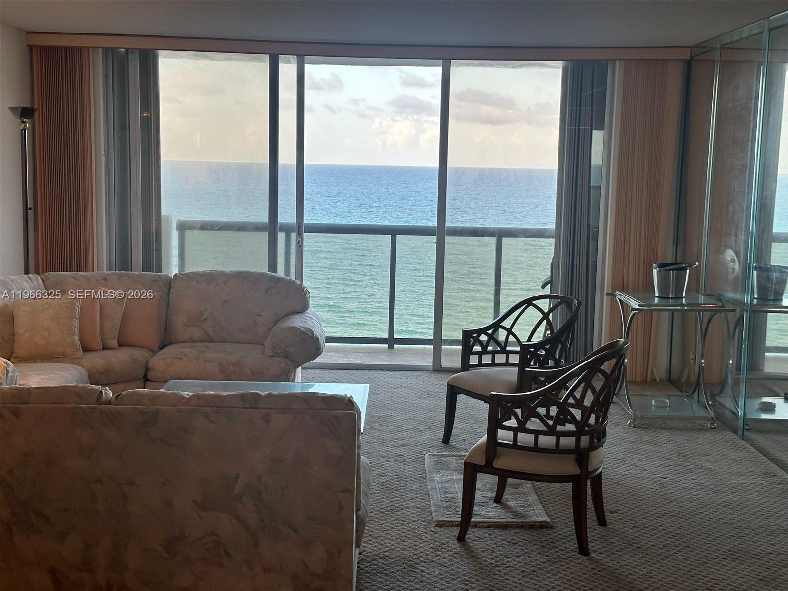6039 Collins Avenue, Unit 1517 Miami Beach, FL 33140 - Photo 5 of 54 a living room with furniture and a large window