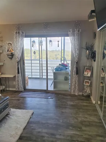 a view of empty room with wooden floor and floor to ceiling window