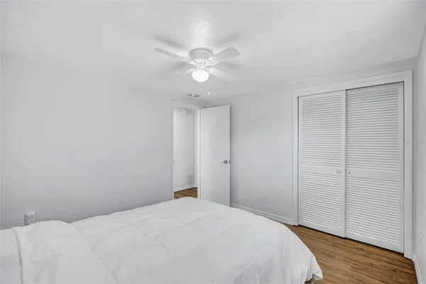 a bedroom with a bed and a chandelier fan