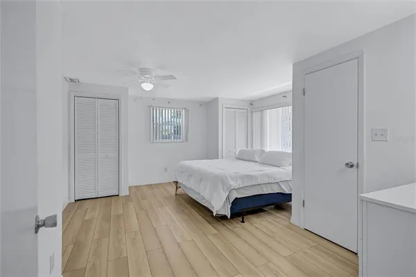 a bedroom with a bed and wooden floor