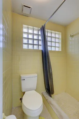 a white toilet sitting next to a window