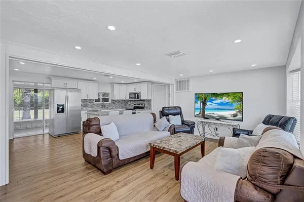 a living room with furniture flat screen tv and wooden floor