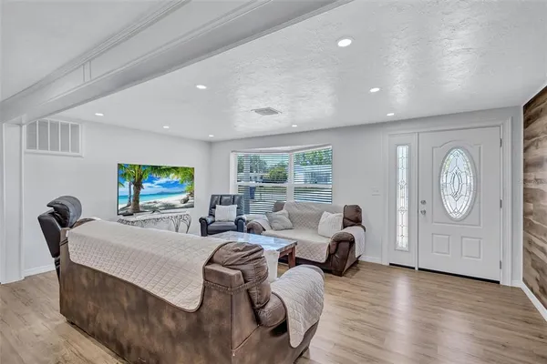 a living room with furniture a window and a flat screen tv
