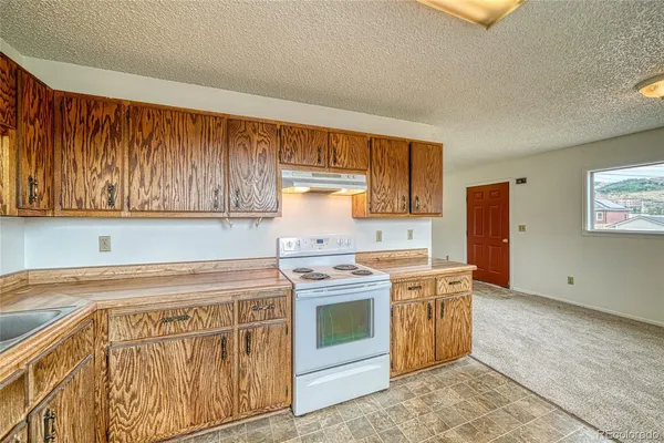 a kitchen with cabinets stainless steel appliances a sink and a window