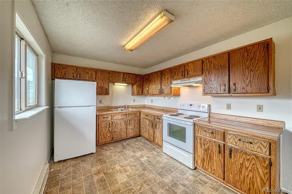 a kitchen with granite countertop cabinets stainless steel appliances a sink and a large window