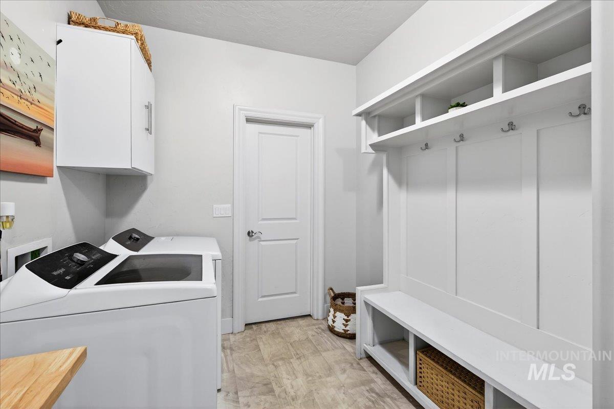 24813 Valley Run Place Star, ID 83669 - Photo 19 of 50 Washroom featuring washer and clothes dryer, a textured ceiling, and cabinet space