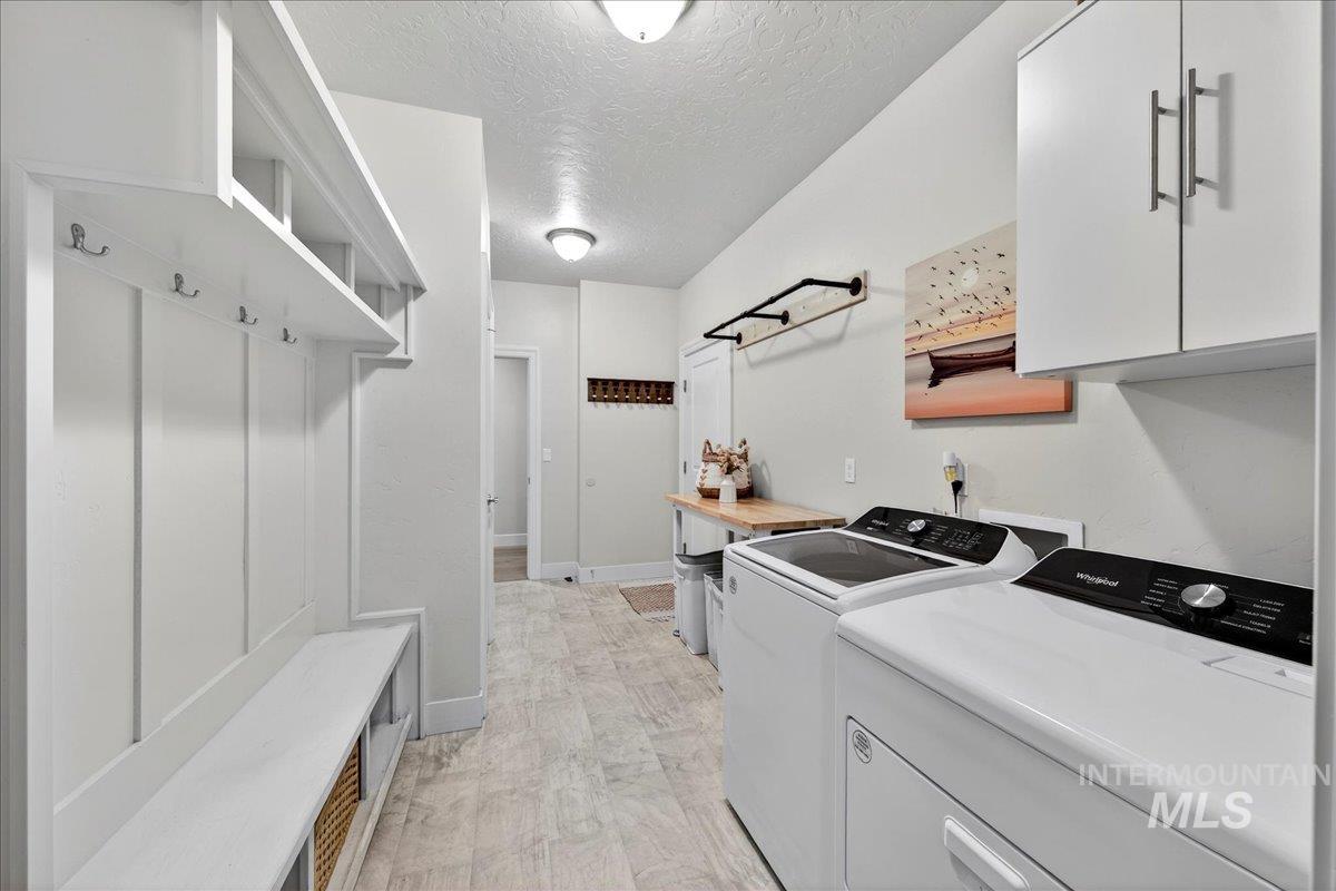 24813 Valley Run Place Star, ID 83669 - Photo 21 of 50 Laundry area featuring cabinet space, a textured ceiling, and washing machine and dryer