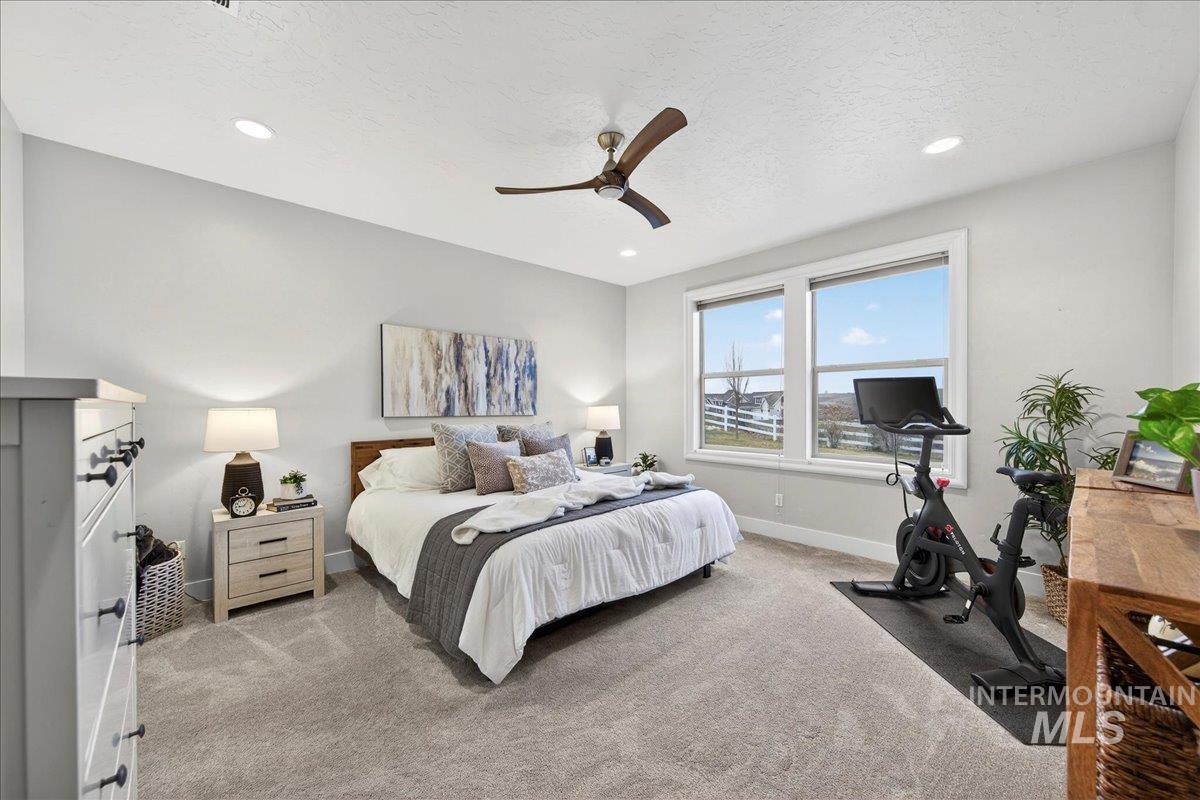 24813 Valley Run Place Star, ID 83669 - Photo 27 of 50 Bedroom with light carpet, a ceiling fan, a textured ceiling, and recessed lighting