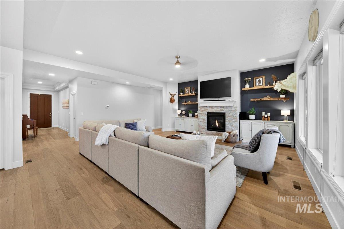24813 Valley Run Place Star, ID 83669 - Photo 6 of 50 Living room featuring light wood finished floors, a fireplace, recessed lighting, and a ceiling fan