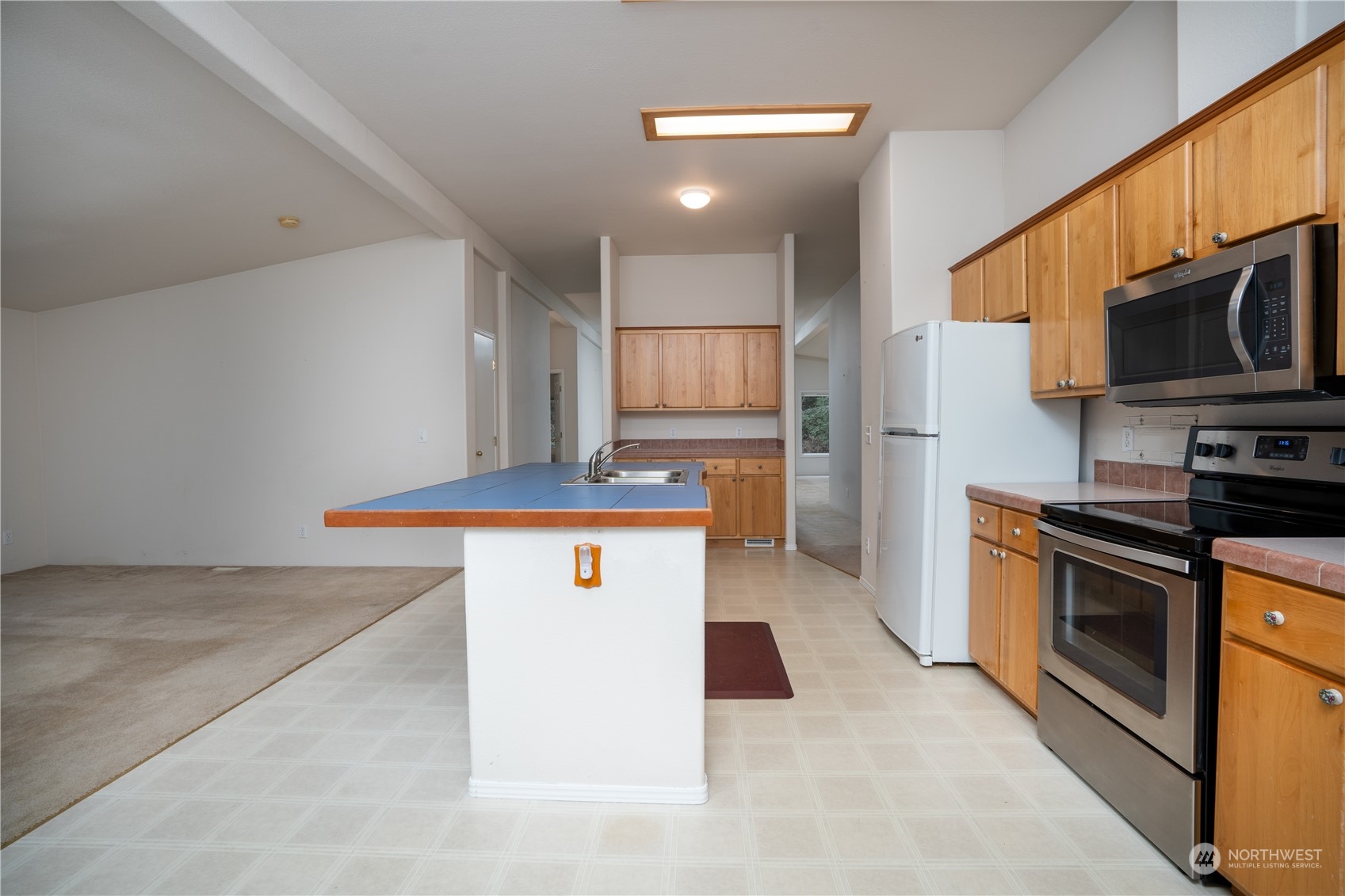 17908 Erickson Road Southwest Longbranch, WA 98351 - Photo 5 of 30 a kitchen with stainless steel appliances granite countertop a sink a stove top oven and refrigerator