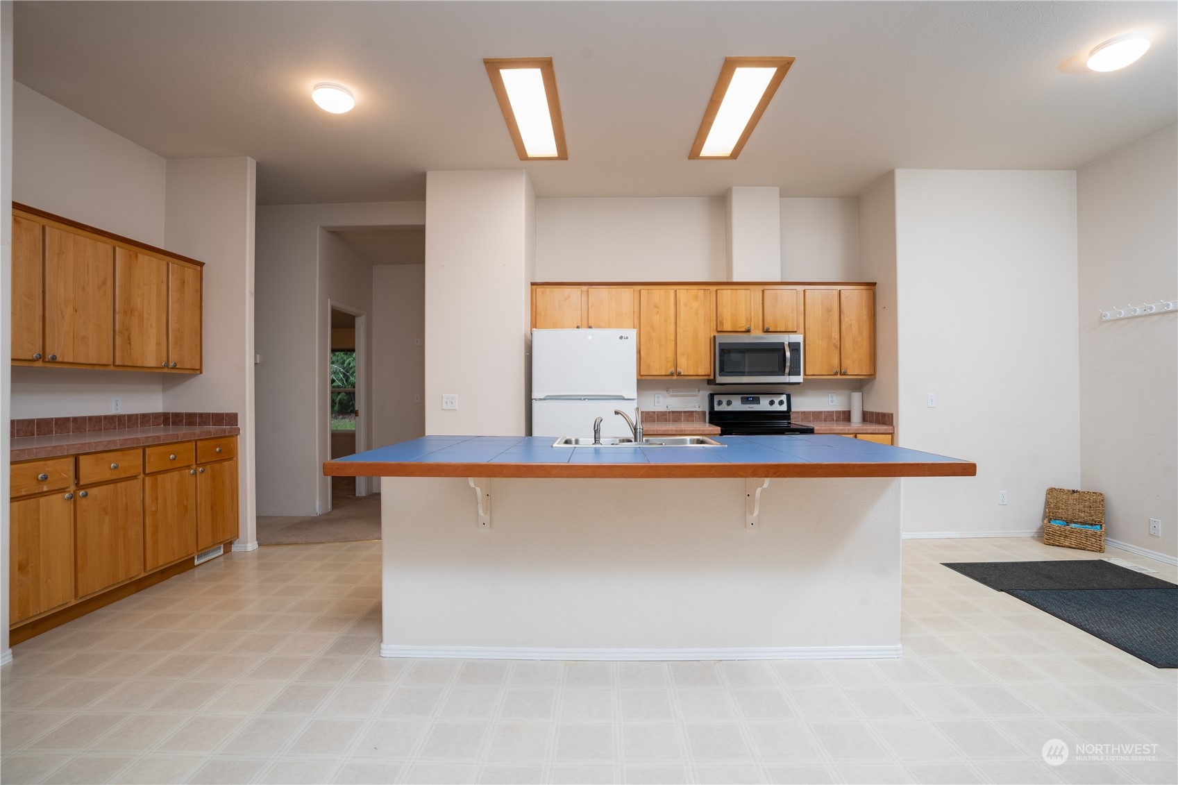 17908 Erickson Road Southwest Longbranch, WA 98351 - Photo 9 of 30 a kitchen with stainless steel appliances a stove a sink a microwave a refrigerator and cabinets