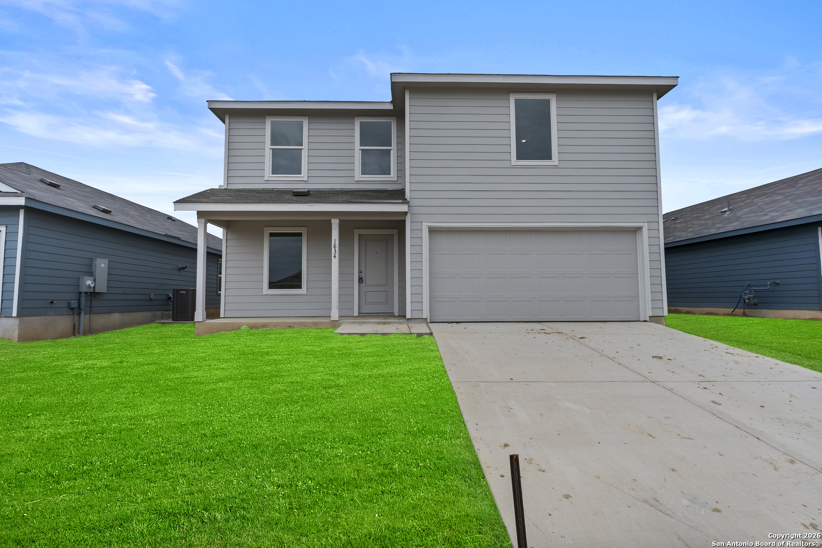 a front view of a house with a garden and garage