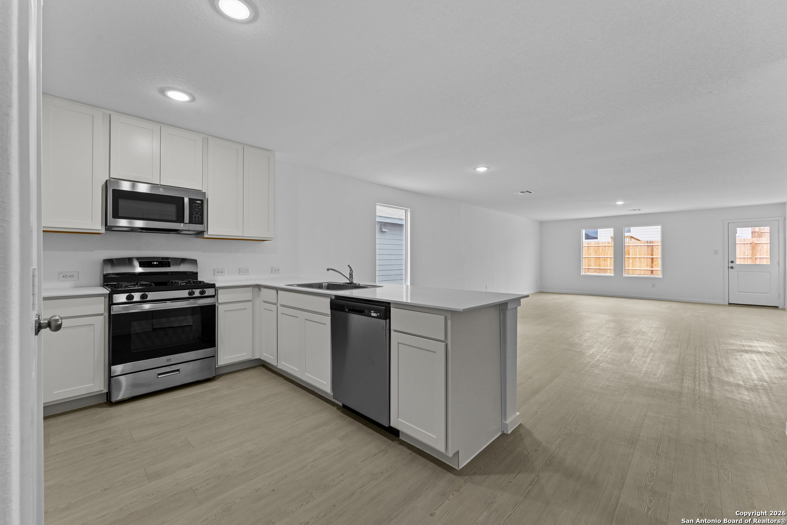 1834 Stonechat New Braunfels, TX 78130 - Photo 4 of 29 a kitchen with stainless steel appliances kitchen island granite countertop a stove a sink and a refrigerator