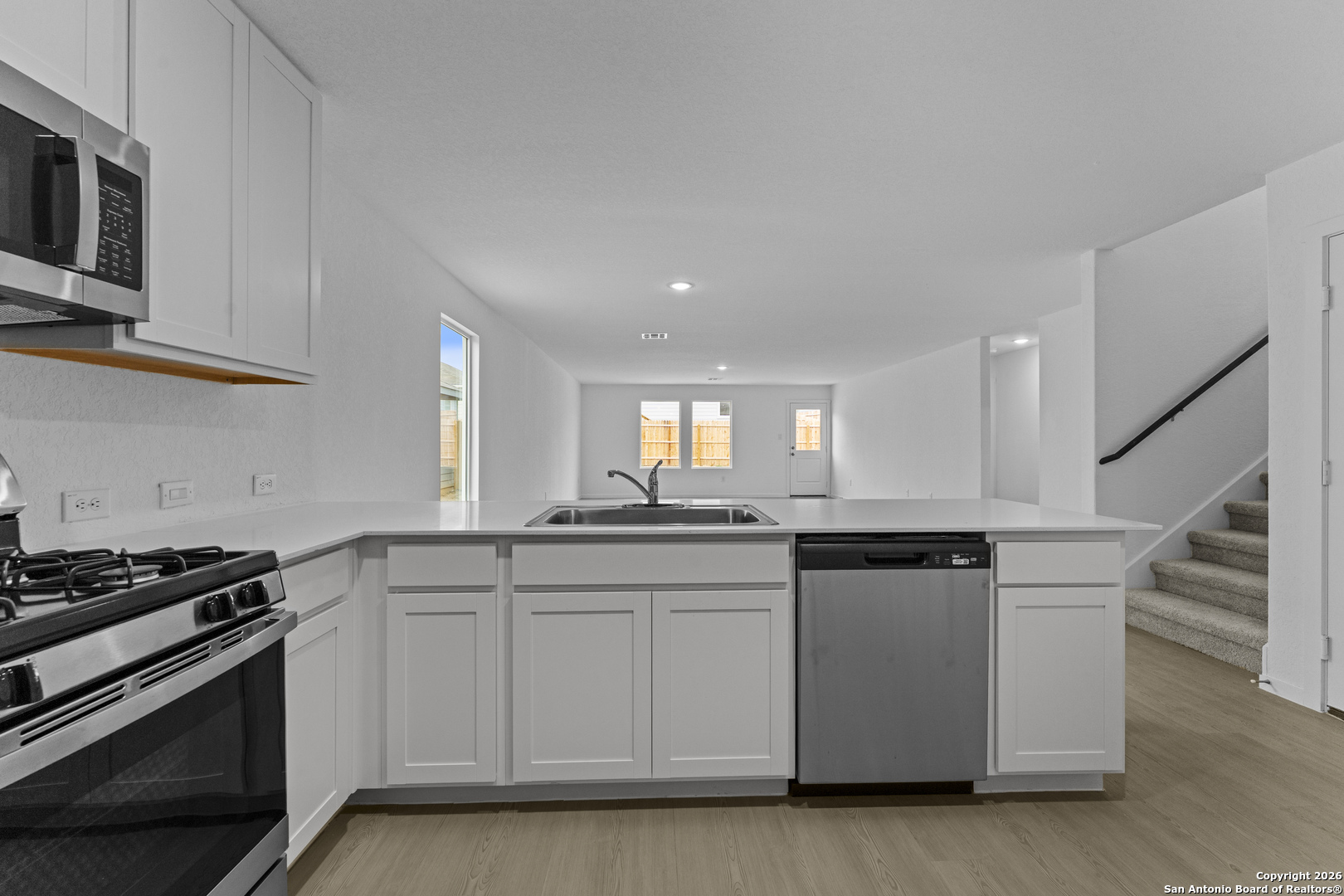 1834 Stonechat New Braunfels, TX 78130 - Photo 6 of 29 a kitchen with granite countertop a sink a stove and cabinets