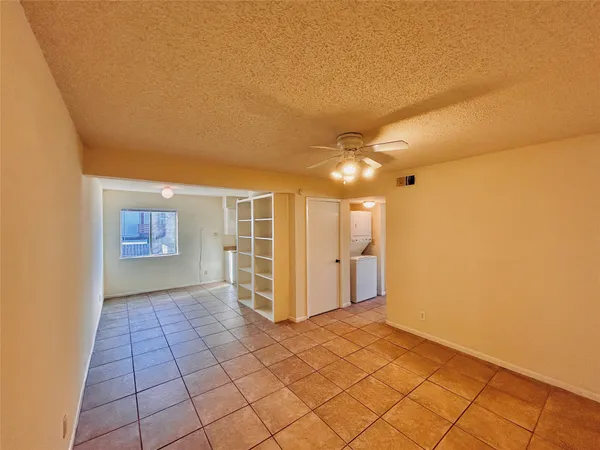 a view of a hallway with wooden floor and a refrigerator