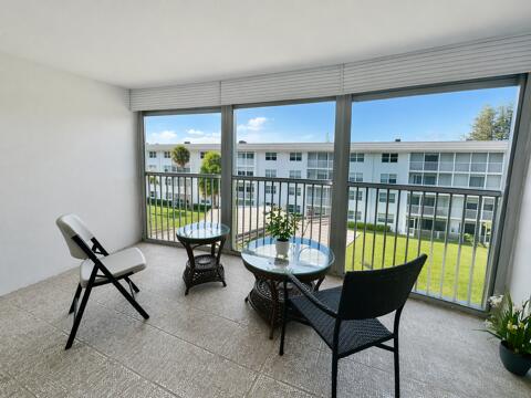 800 East Camino Real, Unit 416 Boca Raton, FL 33432 - Photo 16 of 18 a living room with furniture and a floor to ceiling window