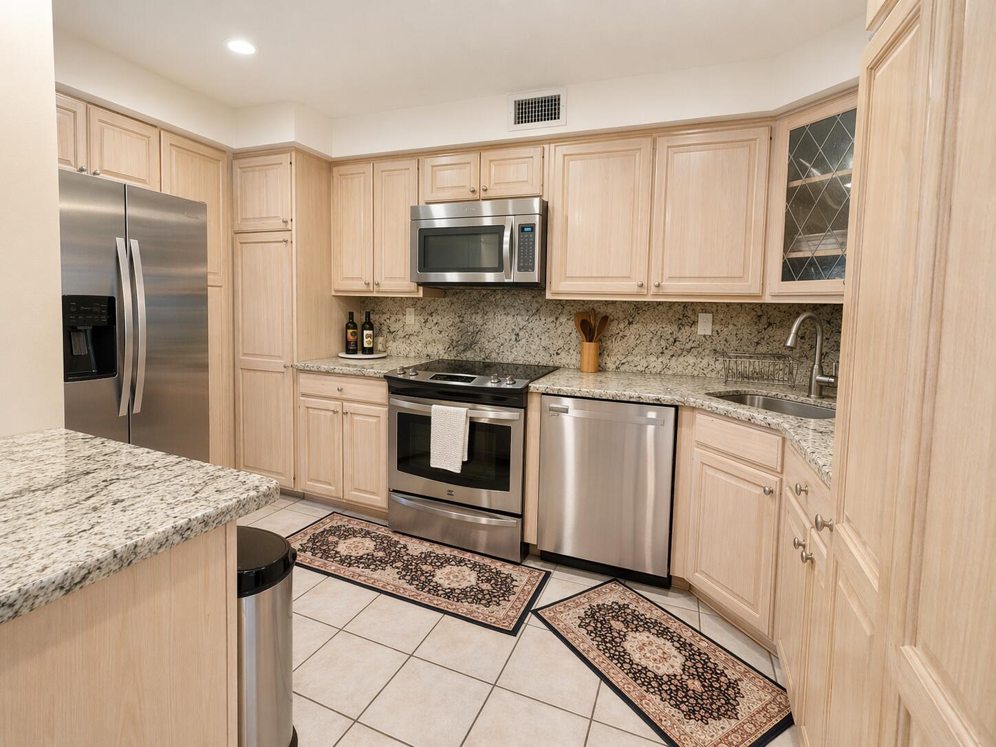 800 East Camino Real, Unit 416 Boca Raton, FL 33432 - Photo 5 of 18 a kitchen with granite countertop a sink stove and refrigerator