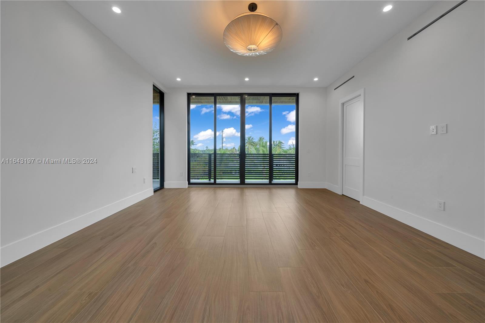 8821 Southwest 56th Street Miami, FL 33165 - Photo 14 of 49 an empty room with wooden floor and windows