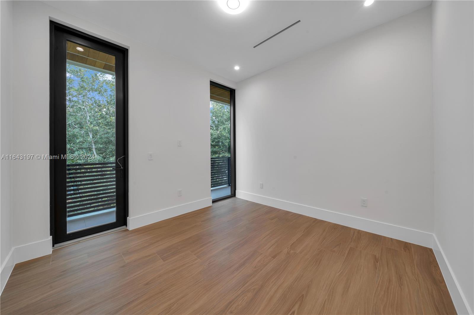 8821 Southwest 56th Street Miami, FL 33165 - Photo 22 of 49 an empty room with wooden floor and windows