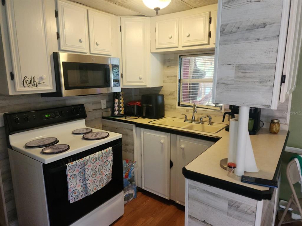 82 Silvio Road Lake Wales, FL 33898 - Photo 10 of 13 a kitchen with stainless steel appliances a stove a microwave a sink and cabinets
